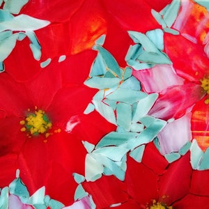 K&ouml;nnte beinhalten: Nahaufnahme eines roten, wei&szlig;en und blauen Glaskunstwerks mit einer Weihnachtsstern-Blume. Die Blume besteht aus vielen kleinen Glassplittern, die einen Mosaik-Effekt erzeugen.