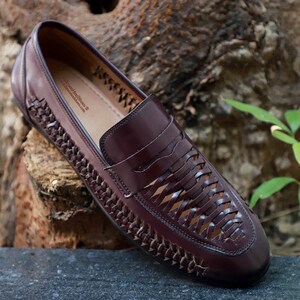 May include: A dark brown leather loafer featuring a woven lattice design across the vamp and sides, with a solid leather strap across the top. The interior insole is printed with the text TallmenHeelShoes and the website tallmenheelshoes.com.