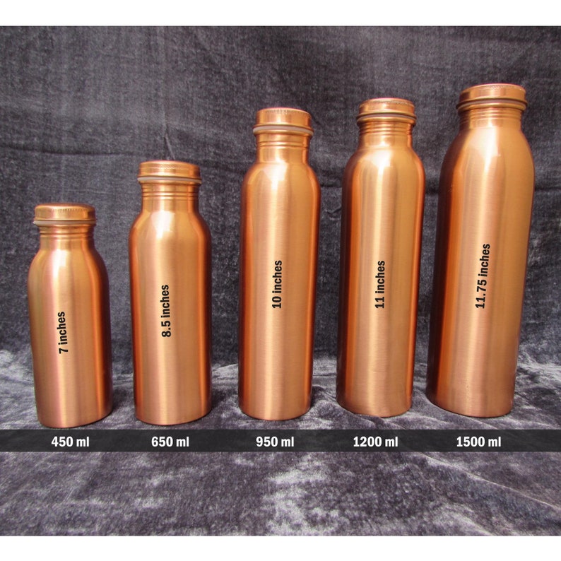 May include: Five copper water bottles of varying sizes are displayed. The bottles range from 7 inches to 11.75 inches in height, with capacities from 450 ml to 1500 ml. Each bottle has a screw-on cap.