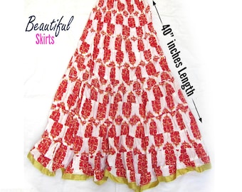 May include: A tiered maxi skirt featuring a white base with a repeating red and gold floral pattern. The skirt has a gold-trimmed hem and a length of 40 inches. Text on the image reads Beautiful Skirts and 40 inches Length, with a color palette bar.