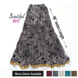 May include: A long, black and white patterned skirt with a gold-colored hem. The skirt features an elastic waistband and a total length of 40 inches as indicated by the text. The image includes the text Beautiful Skirts and More Colors Available.