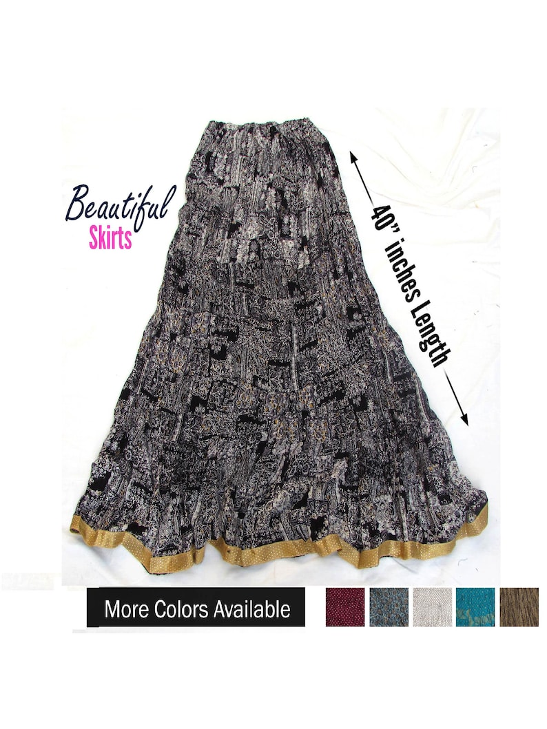 May include: A long, black and white patterned skirt with a gold-colored hem. The skirt features an elastic waistband and a total length of 40 inches as indicated by the text. The image includes the text Beautiful Skirts and More Colors Available.