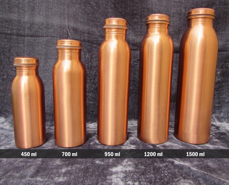 May include: Five copper-colored water bottles of varying sizes are displayed against a dark gray background. The bottles range from small to large, with capacities of 450 ml, 700 ml, 950 ml, 1200 ml, and 1500 ml. Each bottle has a matching screw-on cap.