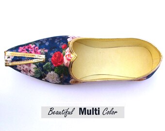 Op de afbeelding: Een instapschoen met een puntige neus, een donkerblauwe stoffen bovenkant met een kleurrijke bloemenprint, goudkleurige randen langs de kraag en neus, en een lichtbeige voering. De tekst "Beautiful Multi Color" staat eronder vermeld.