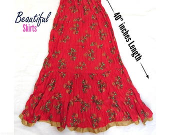May include: A red maxi skirt with a floral pattern, an elastic waistband, and a gold-toned hem. The skirt features a tiered design and measures 40 inches in length. Text on the image reads Beautiful Skirts and More Colors Available.
