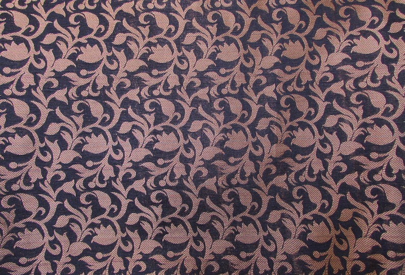 May include: A woven fabric featuring a repeating pattern of light pink floral and paisley-like shapes set against a dark navy blue background. The design consists of interconnected swirling leaves and stylized flower motifs across the surface.