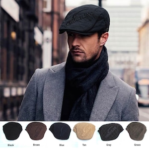 May include: A black flat cap featuring a quilted diamond pattern and the word BUSTLING embossed on the front. The collection includes six color variations: black, brown, blue, tan, gray, and green, each displaying the same quilted design.