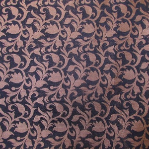 May include: A woven fabric featuring a repeating pattern of dark navy blue and light pink floral motifs. The design consists of intricate, swirling leaf and petal shapes that are densely packed across the entire surface of the textile material.