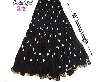 May include: A black skirt with white polka dots and a crinkled texture. The skirt features a gold-toned trim along the hemline and has a total length of 40 inches. The text Beautiful Skirts is visible in the upper left corner of the image.