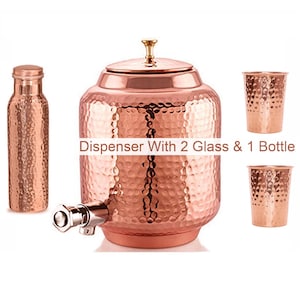 Könnte beinhalten: Kupfer-Wasserspender-Set mit gehämmerten Texturen, einschließlich einer Flasche, zwei Gläsern und einem Spender mit Auslauf. Das Set hat ein glänzendes Finish und den Text "Dispenser With 2 Glass & 1 Bottle".