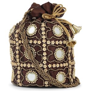 Puede incluir: Bolsa marrón con cordón, adornada con abalorios dorados y espejos. La bolsa presenta un patrón floral y borlas doradas, creando un accesorio elegante y decorativo. Fabricada en un material suave similar al satén.