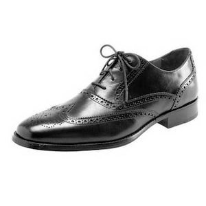 May include: A black leather oxford shoe featuring a classic wingtip design with decorative brogue perforations along the seams, a rounded toe, a low stacked heel, and thin black laces tied in a bow across the top of the vamp.