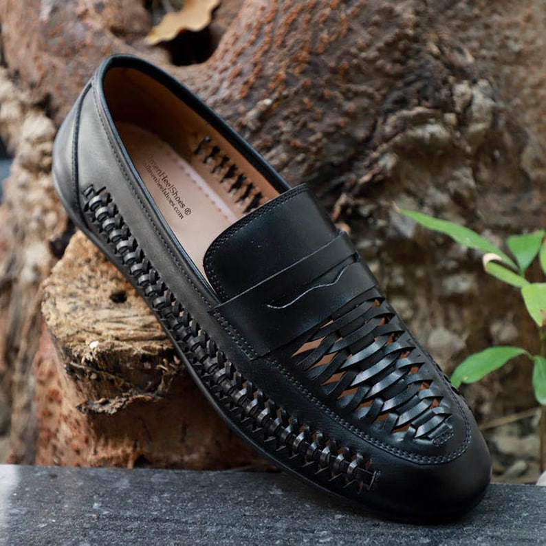 May include: A black leather loafer featuring a woven lattice design across the vamp and sides, with a solid leather strap across the top. The interior insole is tan and displays the text LinenHeelShoes.com in black lettering.
