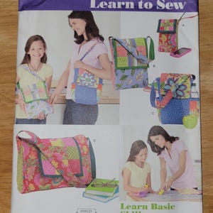 May include: A Simplicity 1935 Learn to Sew pattern envelope featuring instructions and illustrations for creating four different styles of quilted fabric bags. The cover displays colorful patchwork designs, floral patterns, and shoulder straps.