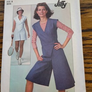 May include: Simplicity sewing pattern number 7958 for a Jiffy pattern. The pattern is for a size 8 miss and includes two styles: a white wrap dress and a blue denim jumpsuit with a red and white striped top.