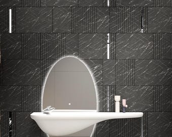 May include: A modern bathroom vanity with a white, oval-shaped sink and a large, oval mirror with a white light around the edge. The vanity is mounted on a black tiled wall.