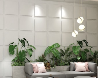 May include: A modern, minimalist waiting area with a white reception desk, a gray sectional sofa with pink pillows, and potted plants. The room has a white tiled floor and a white wall with a grid pattern.