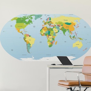 May include: A large, oval-shaped world map wall sticker on a white wall. The map displays countries in different colours against a light blue ocean. A brown leather office chair and a desk with a laptop are in the foreground, with a clock on the wall.