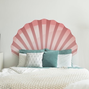 Può includere: Una camera da letto con un letto bianco con una coperta in crochet bianca e una gonna del letto blu turchese. La testiera è un design a conchiglia rosa e bianca.