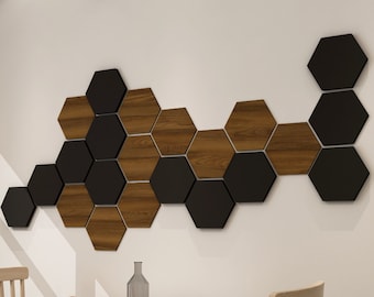 May include: A wall decor made of hexagonal wooden and black tiles arranged in a wave pattern. The tiles are mounted on a white wall.