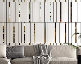 May include: A modern living room with a sectional sofa, a coffee table, and a decorative wall with vertical panels. The sofa is upholstered in a light beige fabric and has a throw blanket draped over it. The coffee table is made of a rough-hewn stone and has a black glass top. The wall is made of white panels with gold accents.