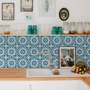 Può includere: Un paraschizzi da cucina con un motivo geometrico a stella ripetuto nei toni del verde acqua, blu navy e bianco. Le piastrelle sono installate dietro un rubinetto in acciaio inossidabile e un lavello bianco su un piano di lavoro in legno chiaro.