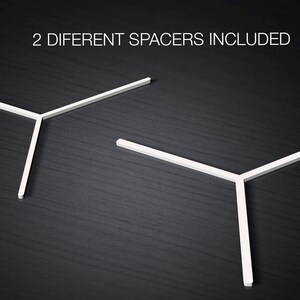 May include: Two white plastic spacers, shaped like a Y, are shown on a dark wood surface. The text "2 DIFFERENT SPACERS INCLUDED" is above the spacers.