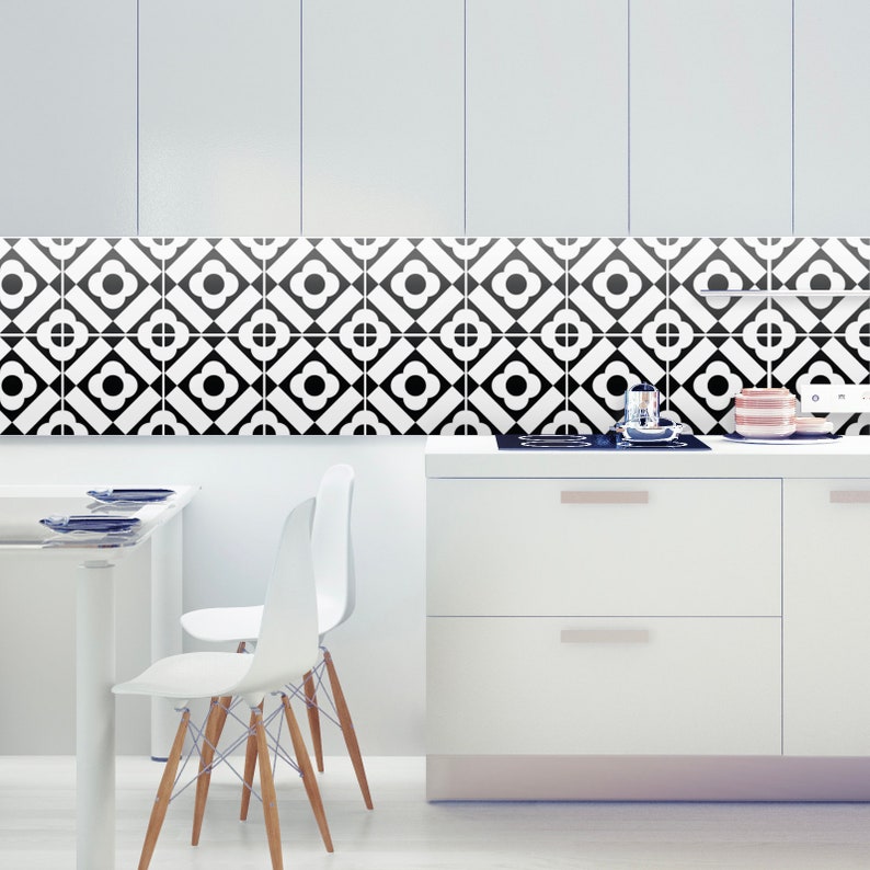 Puede incluir: Un salpicadero de cocina con un patr&oacute;n geom&eacute;trico repetitivo de azulejos cuadrados en blanco y negro. Cada azulejo muestra un motivo circular central rodeado por cuatro p&eacute;talos dentro de un marco de diamante, creando un dise&ntilde;o gr&aacute;fico continuo.