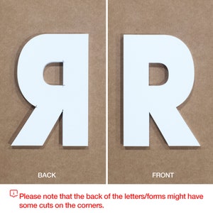 May include: White letter R, front and back views. The back of the letter has cuts on the corners.