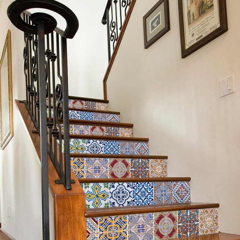 Puede incluir: Un conjunto de pegatinas de azulejos con patrones coloridos para escaleras. Las pegatinas son de varios colores azules, amarillos, rojos y verdes. Las pegatinas est&aacute;n dispuestas en un patr&oacute;n de mosaico. Las pegatinas se aplican a un conjunto de escaleras de madera con una barandilla de metal negro.