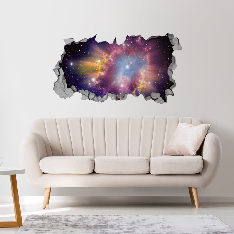 May include: A wall decal depicting a 3D effect of a hole revealing a vibrant galaxy. The galaxy features swirling colors of purple, blue, yellow, and white, with numerous stars. The decal is framed by a gray, cracked wall effect.