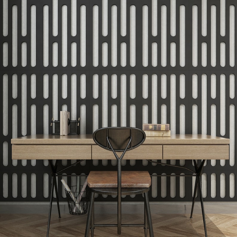 May include: A modern office setup featuring a light wood desk with three drawers, a black metal chair with a brown seat, and a black wire basket. The background is a black and white patterned wall. Books and desk accessories are on the desk.
