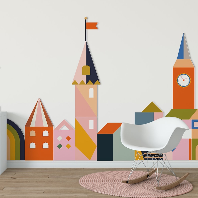 3D City Houses in pink, orange, green, and blue on a white wall in a playroom.