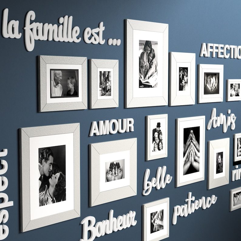 May include: A blue wall with white framed photos and white 3D letters spelling out the phrase "la famille est..." and other words in French. The photos are black and white and feature people.