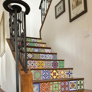 May include: A staircase featuring decorative tile stickers on each riser. The tiles display a variety of colorful geometric and floral patterns in shades of blue, yellow, red, green, and white, contrasting with the dark wood steps and black railing.