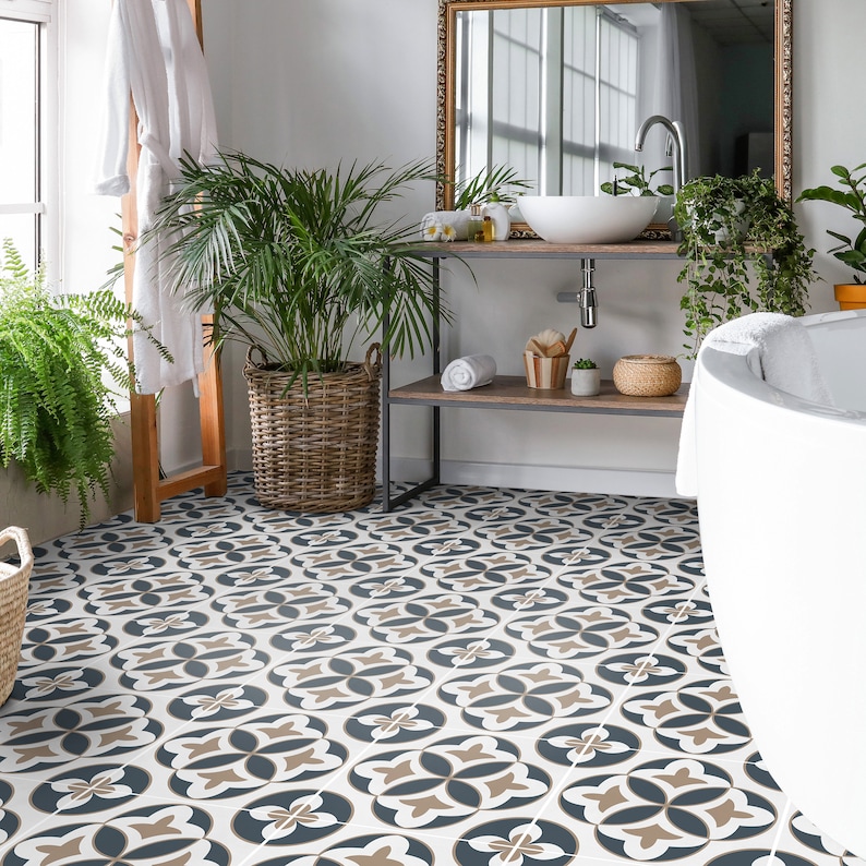 Puede incluir: Un suelo de ba&ntilde;o con baldosas cuadradas que presentan un patr&oacute;n geom&eacute;trico repetitivo en azul oscuro, beige y blanco. El dise&ntilde;o consiste en formas florales de cuatro p&eacute;talos dispuestas en cuadr&iacute;cula, creando un motivo decorativo continuo.