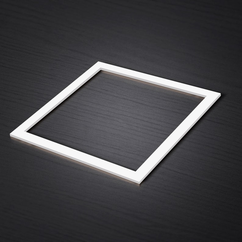 May include: A white square frame on a black textured surface.