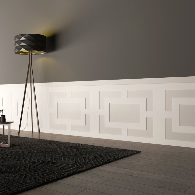 May include: A black floor lamp with a geometric shade illuminates a room with white wainscoting and a black and gray patterned rug. The wainscoting features a geometric design.