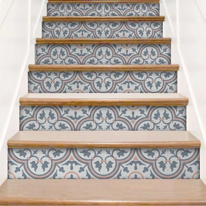 Puede incluir: Una escalera con adhesivos decorativos en los contrahuellas que presentan un patr&oacute;n repetitivo en tonos azul pizarra, melocot&oacute;n suave y blanco. El dise&ntilde;o consiste en motivos circulares entrelazados y elementos florales en las contrahuellas.