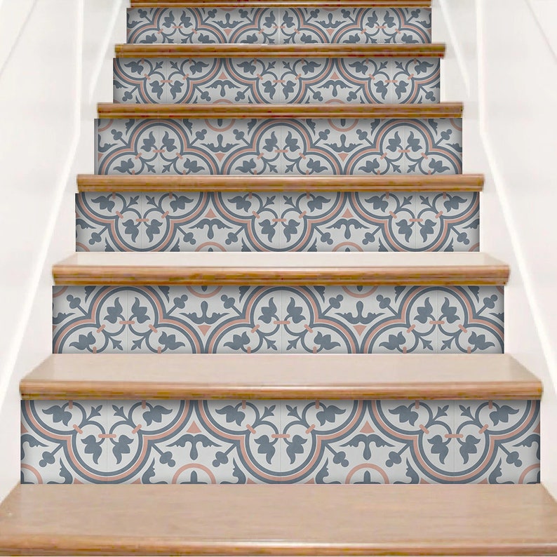 Puede incluir: Una escalera con adhesivos decorativos en los contrahuellas que presentan un patr&oacute;n repetitivo en tonos azul pizarra, melocot&oacute;n suave y blanco. El dise&ntilde;o consiste en motivos circulares entrelazados y elementos florales en las contrahuellas.