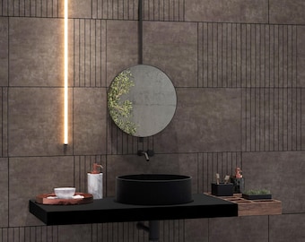 May include: A black bathroom vanity with a round black sink, a round mirror with a green plant reflection, and a black metal towel bar. The vanity has a wooden shelf with a small plant, a soap dispenser, and a small bowl.
