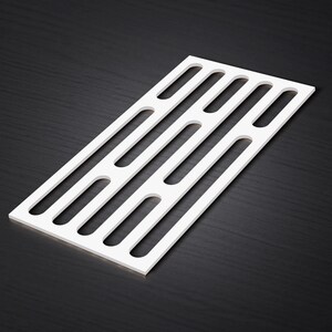May include: A white rectangular panel with a series of evenly spaced, elongated cutouts. The panel is positioned diagonally, showcasing its clean lines and minimalist design. The background is a dark, textured surface.