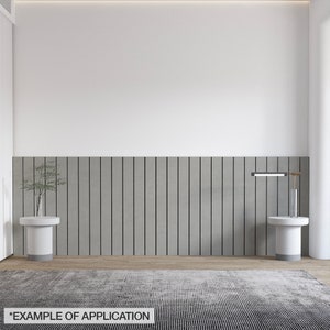 K&ouml;nnte beinhalten: Ein modernes Innendesign mit neutraler Farbpalette. Das Bild zeigt einen grau-schwarz gestreiften Teppich, zwei wei&szlig;e Beistelltische, eine graue vertikale Wandverkleidung und eine kleine Pflanze. Der Text "*EXAMPLE OF APPLICATION" befindet sich unten.