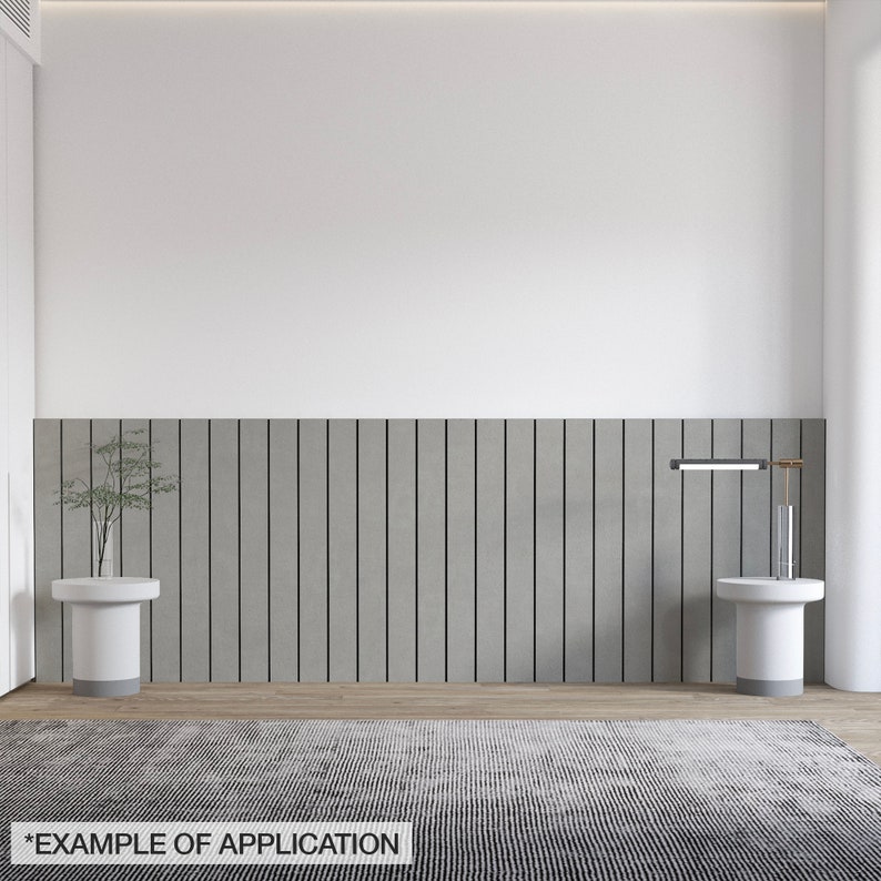 K&ouml;nnte beinhalten: Ein modernes Innendesign mit neutraler Farbpalette. Das Bild zeigt einen grau-schwarz gestreiften Teppich, zwei wei&szlig;e Beistelltische, eine graue vertikale Wandverkleidung und eine kleine Pflanze. Der Text "*EXAMPLE OF APPLICATION" befindet sich unten.