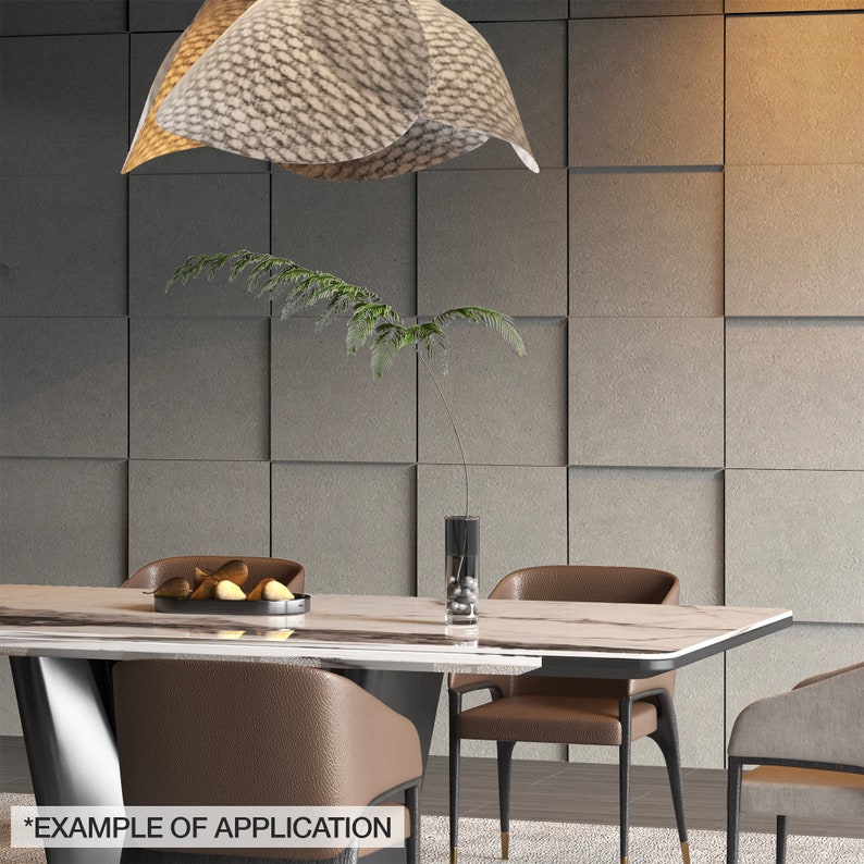 K&ouml;nnte beinhalten: Ein modernes Esszimmer mit einem rechteckigen Tisch mit Marmorplatte und braunen Lederst&uuml;hlen. &Uuml;ber dem Tisch h&auml;ngt eine dekorative Leuchte. Eine Vase mit einer Pflanze und eine Schale mit Obst stehen auf dem Tisch. Die Wand ist grau mit einem quadratischen Muster.
