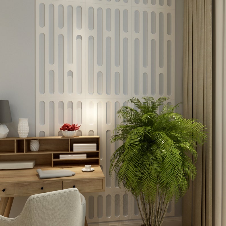 May include: A home office setup featuring a light wood desk with drawers, a gray chair, and a white wall with a repeating vertical design. A green plant and a gray lamp add to the decor. A small white vase and a red flower arrangement are on the desk.