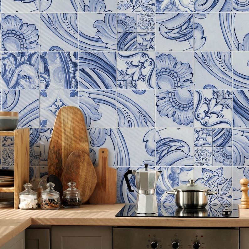 Op de afbeelding: Een aanrecht met een zilveren mokkapot, een roestvrijstalen pan, drie glazen potten met deksels en drie houten snijplanken in verschillende vormen. De muur achter het aanrecht is bedekt met vierkante tegels met blauwe bloemmotieven.