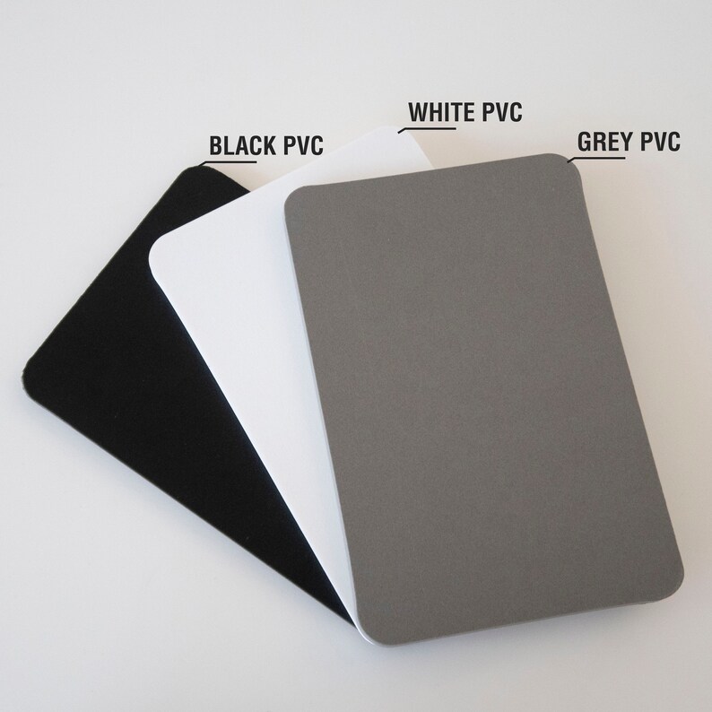 May include: Three sheets of PVC material in black, white, and gray. The sheets are stacked on top of each other, with the black sheet on the bottom, the white sheet in the middle, and the gray sheet on top.