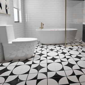 May include: A white toilet and a white bathtub with a gold faucet in a bathroom with black and white geometric floor tiles.