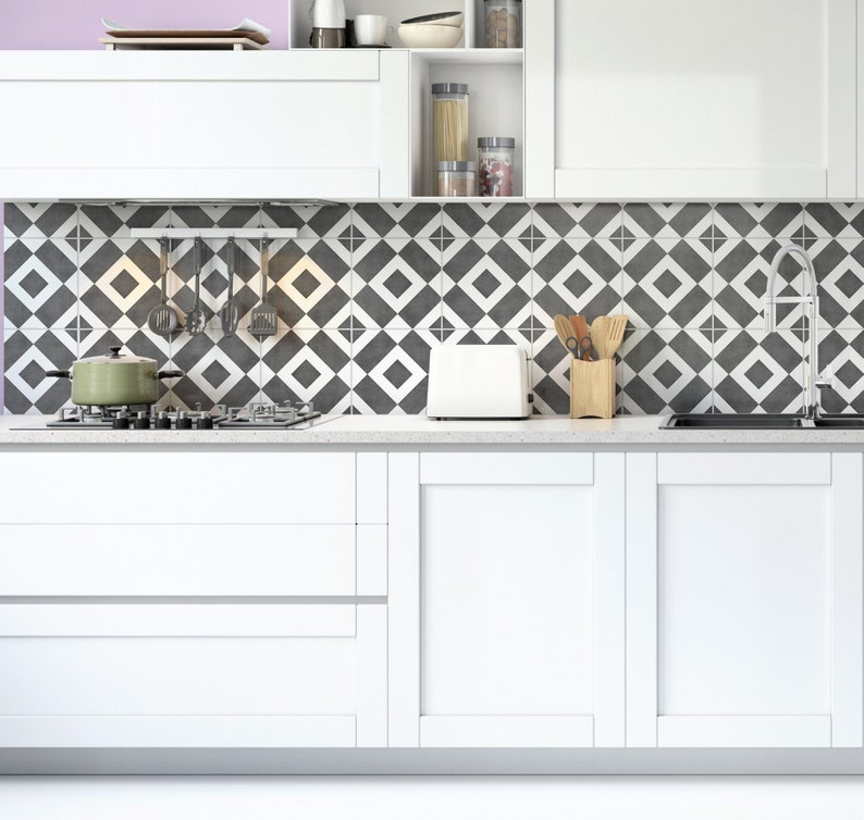 White tile stickers with a dark grey rhombuses pattern on a white kitchen backsplash.